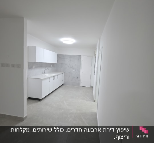 מטבח חדש עם ארונות לבנים ורצפת שיש אפורה